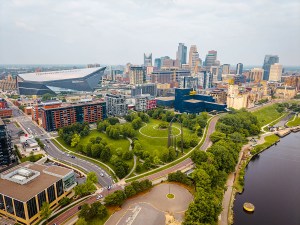 Minneapolis, MN, USA - June 10, 2025: Mississippi River, historic Stone Arch Bridge, US Bank Stadium, and modern skyscrapers