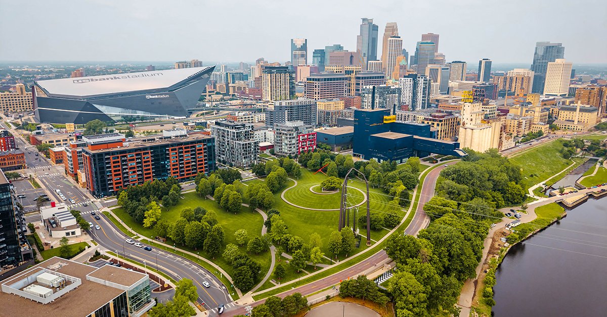 Minneapolis, MN, USA - June 10, 2025: Mississippi River, historic Stone Arch Bridge, US Bank Stadium, and modern skyscrapers