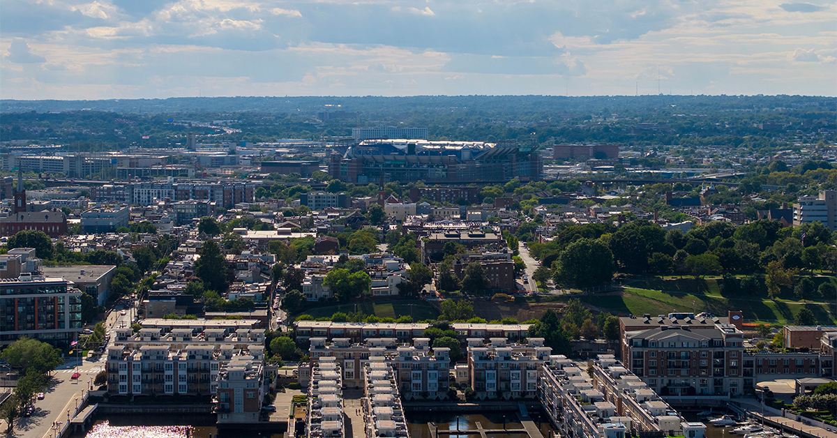 An aerial view of Baltimore skyline with waterfront apartments and cityscape under bright clouds, USA