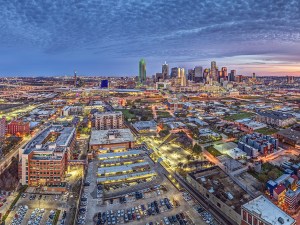 Colorful drone evening panorama of Dallas with dramatic sky and illuminated cityscape
