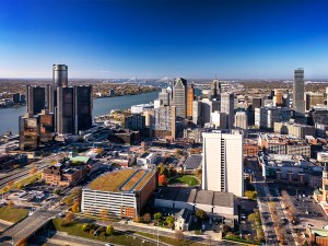 Aerial of Downtown Detroit skyline (including the new Hudson Tower), with the Detroit River, city of Windsor (Canada), Ambassador Bridge (smaller bridge), and Gordi Howe International Bridge (larger bridge) in the background.