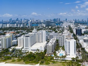 Miami beach with turquoise waters. Aerial view of sandy coastline and waves. Tropical Miami Beach scene with sandy beach. Oceanfront of South Miami. Panoramic of Miami Beach