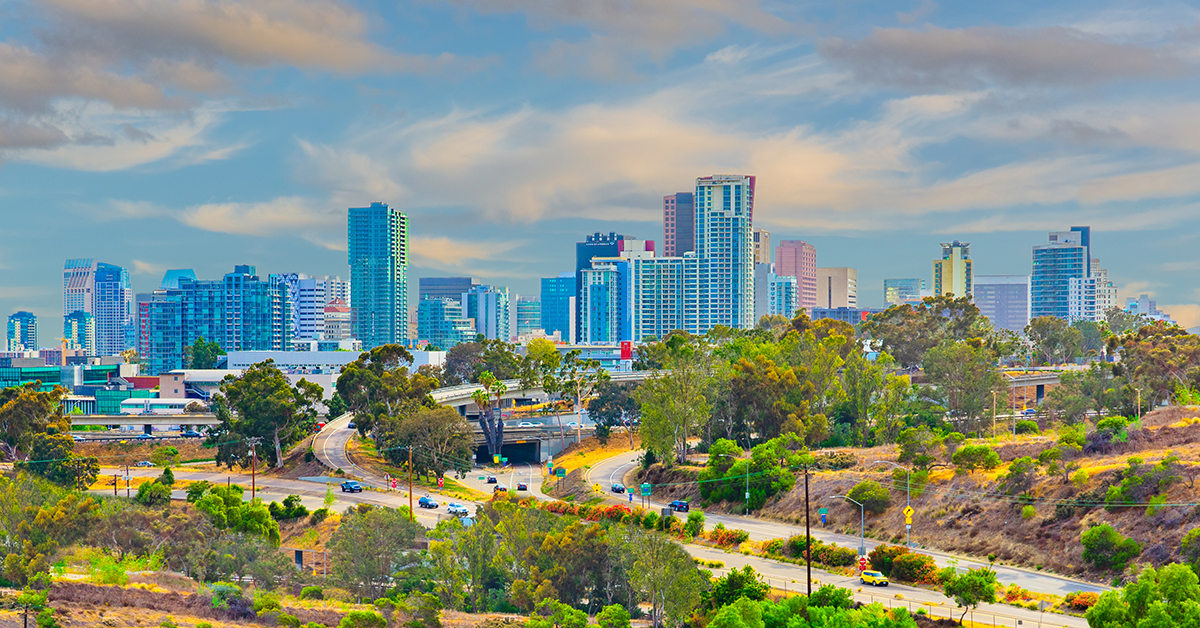 Lush foliage fills the hillside in front of San Diego skyline which is a city on the Pacific coast of California known for its beaches, parks and warm climate