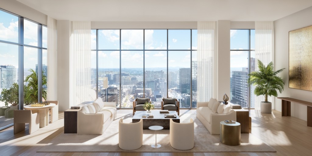 Luxurious penthouse living room with large windows offering a cityscape view. Features beige sofas, modern decor, and tall plants, creating an airy, elegant atmosphere.