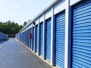Exterior shot of self storage units with blue doors.