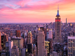 A photo of the Manhattan skyline at sunset, showcasing the Empire State Building.
