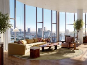 Luxurious living room with floor-to-ceiling windows offering a city skyline view. Features a beige sofa, wooden coffee table, plants, and warm lighting.