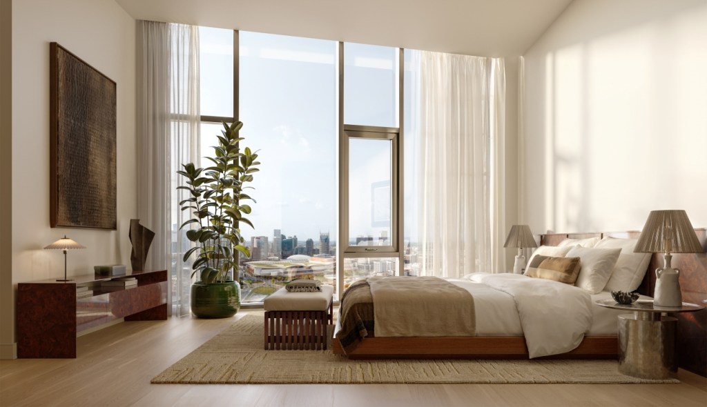 Luxurious bedroom with a large bed, modern furniture, and a floor-to-ceiling window overlooking a cityscape. Sunlight streams in, creating a serene atmosphere.
