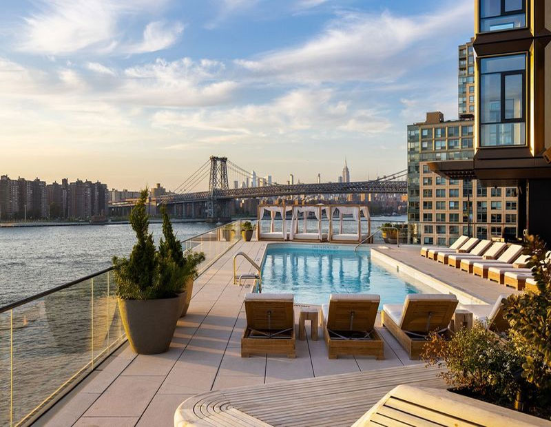 Rendering of Williamsburg Wharf's waterfront pool with a view of Williamsburg Bridge
