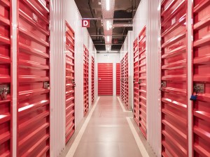 Locked red doors in corridor of self-storage facility.