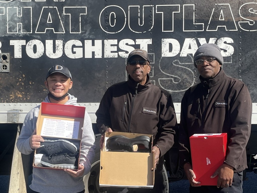 Maintenance team members at County Place receive new boots.