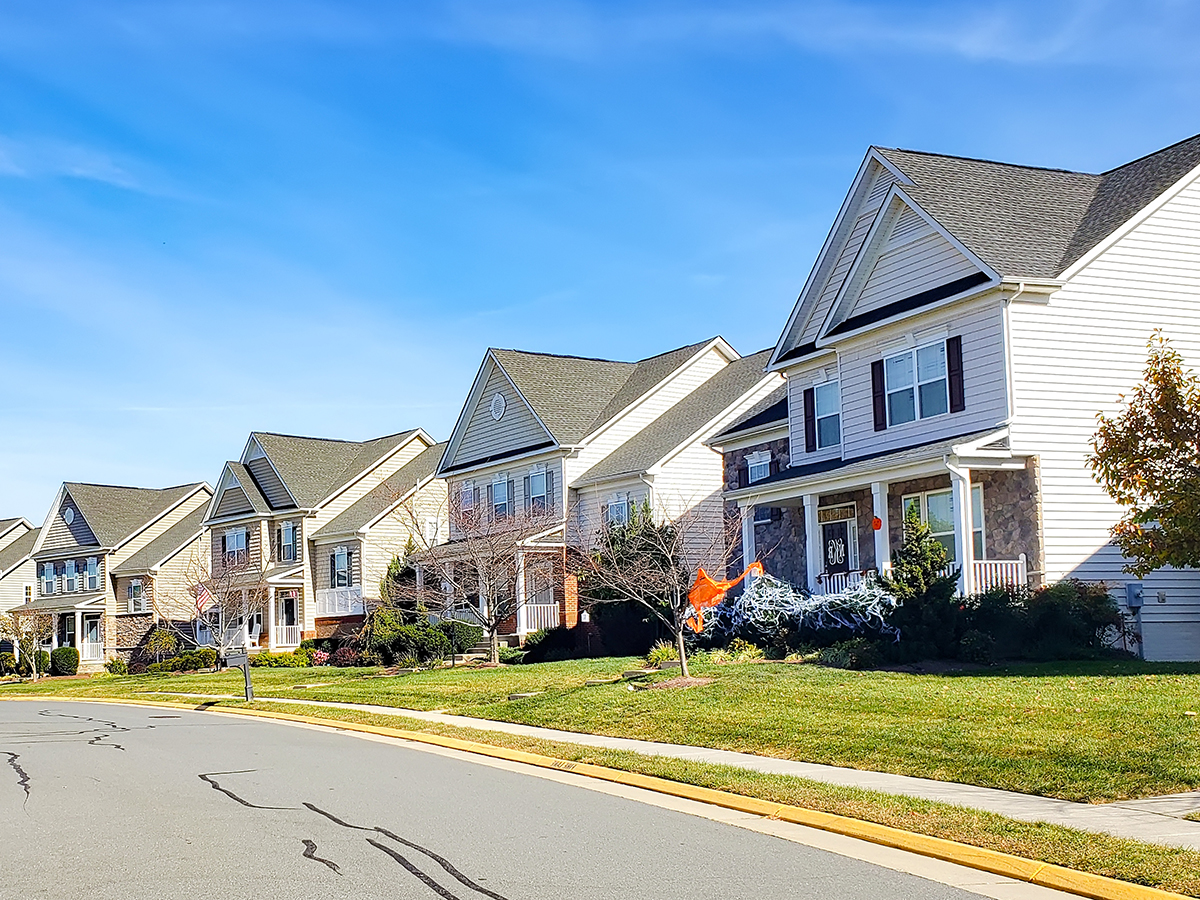 neighborhood of detached houses by the road. Modern single family homes.