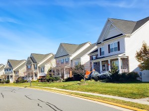 neighborhood of detached houses by the road. Modern single family homes.