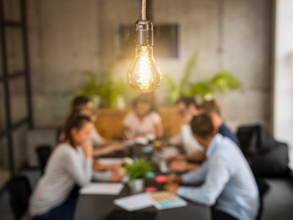 Picture of people in a meeting sitting at a table.