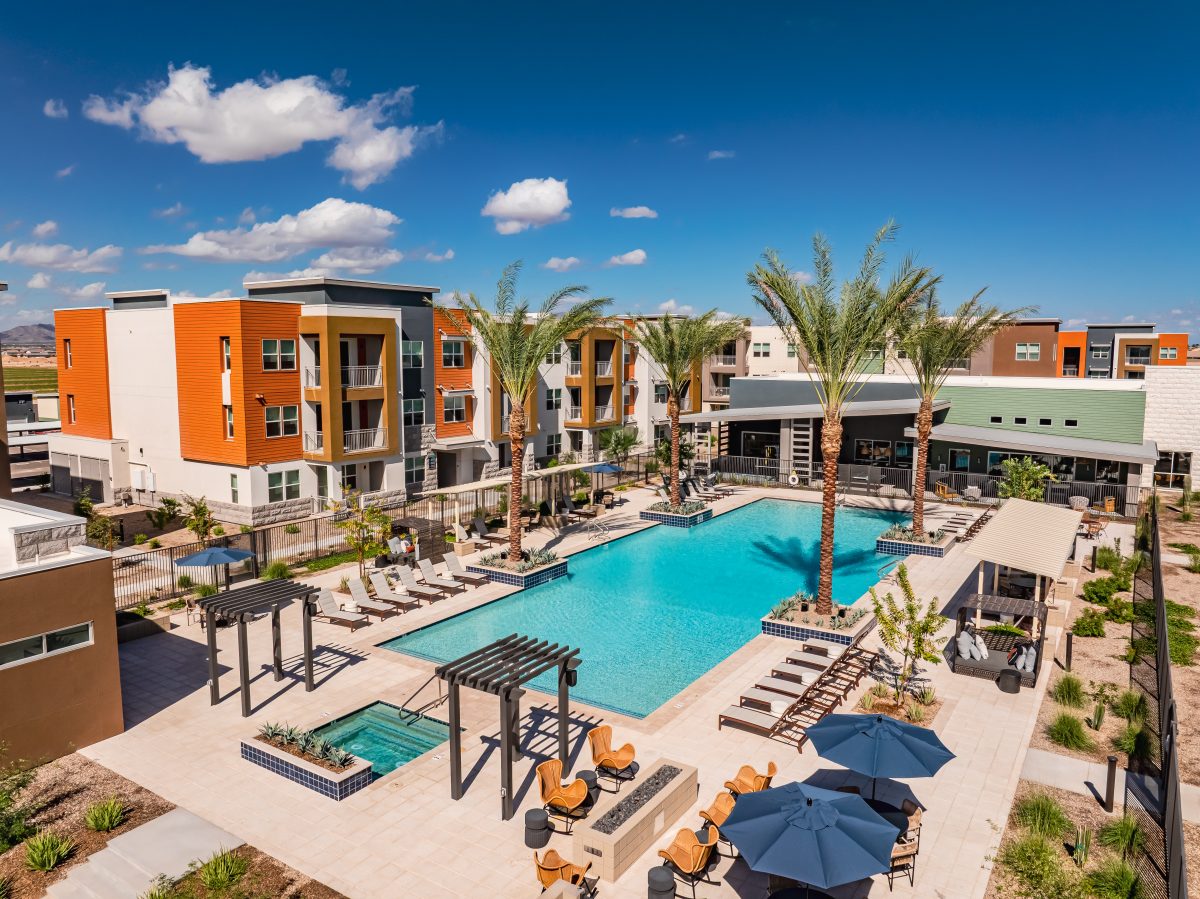 Exterior of Origins Apartments in Goodyear, Ariz., with a swimming pool in the foreground