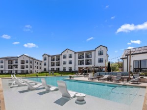 Exterior shot depicting one of the multifamily buildings that make up Birwood Heights, as well as part of its amenity package, in San Antonio.