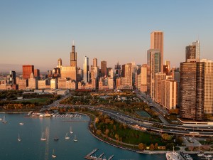 Aerial view of the Chicago skyline beside the lakefront in warm sunrise light.