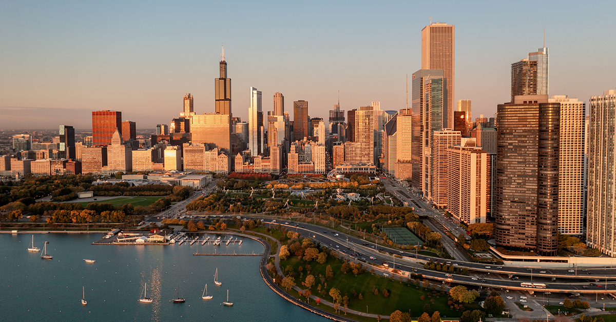 Aerial view of the Chicago skyline beside the lakefront in warm sunrise light.