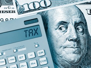 Image of a calculator that has TAX on the screen on top of money.