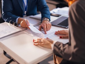 The real estate agent closes the deal with the client and they sign the contract.